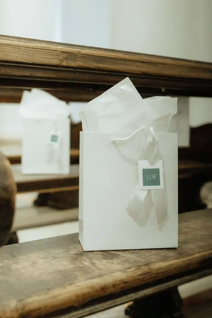 Borsa regalo bianca personalizzata con logo e fiocco per gli ospiti del matrimonio.